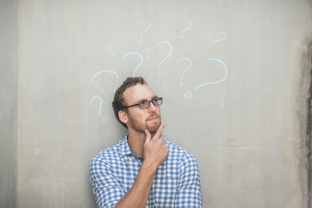 A man thinking in front of a chalkboard